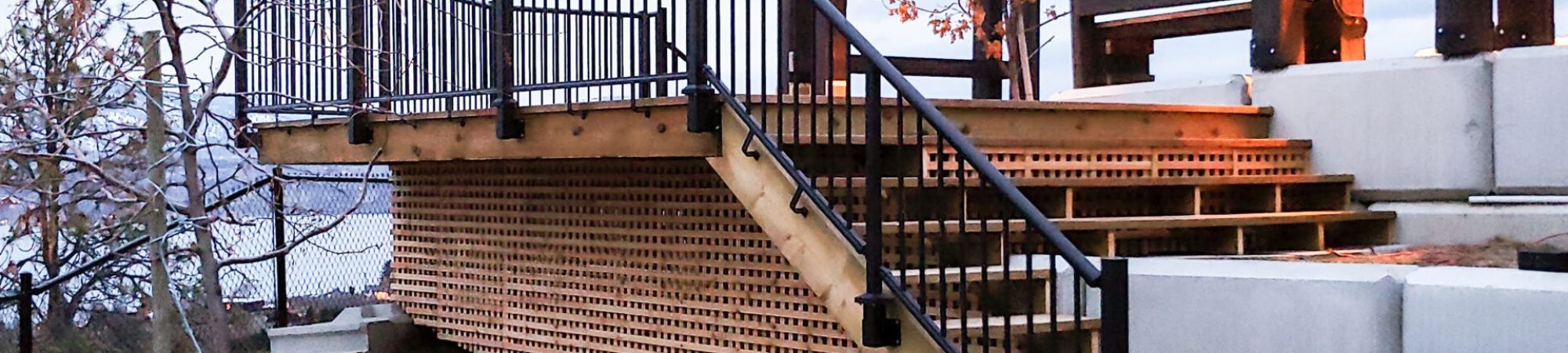 Fascia mount black picket railing installed on a deck and outdoor staircase