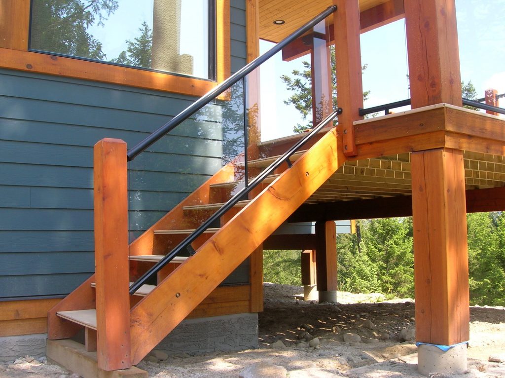 Aluminum and glass stair railings connected to wood balusters