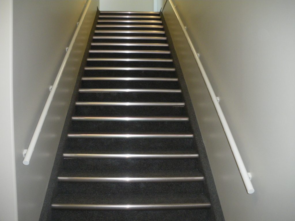 Commercial building with white pipe handrail in the entry staircase