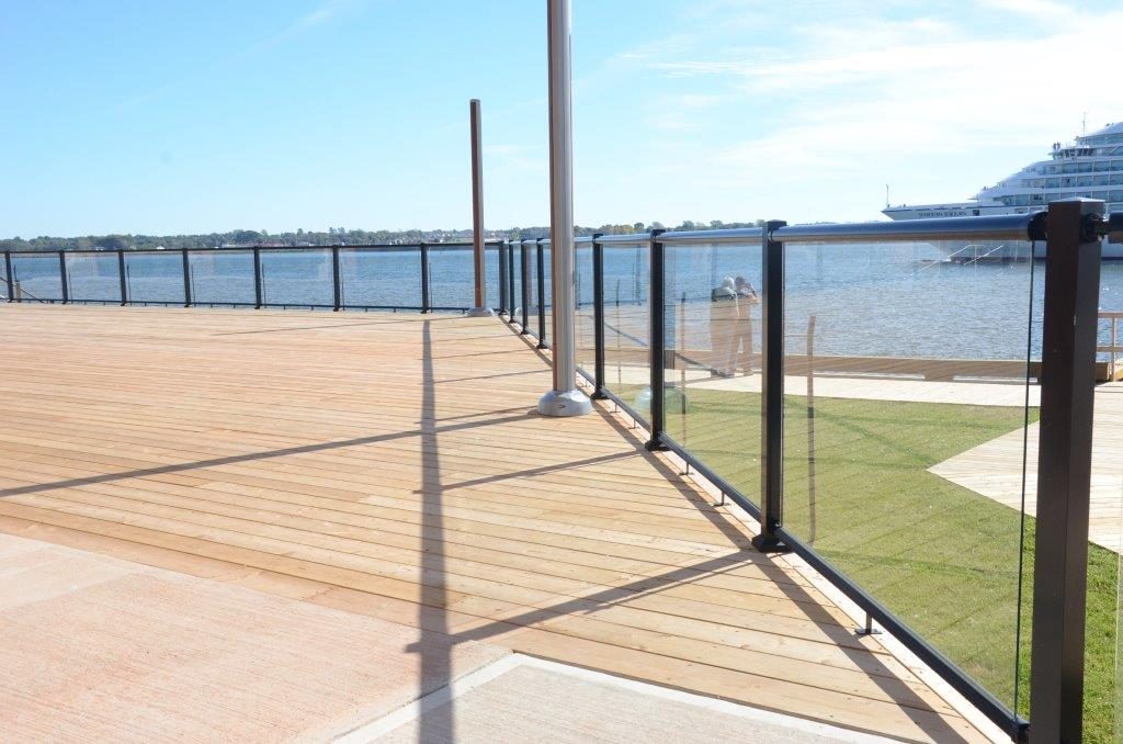 Large outdoor deck space with surface mount glass railings and black aluminum top and bottom rails