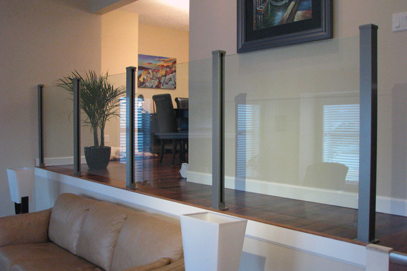 Topless interior glass railings with full length posts in a split-level living room